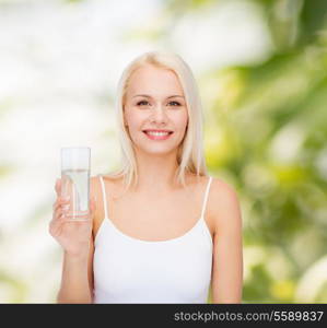 health and beauty concept - young smiling woman with glass of water