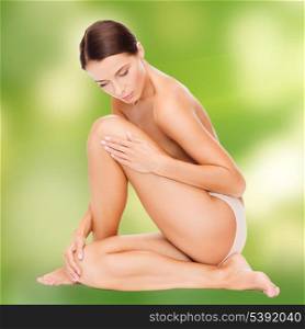 health and beauty, eco, bio, nature concept - beautiful naked woman touching her legs