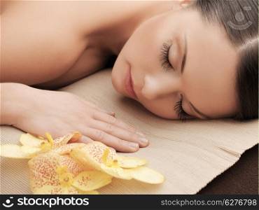 health and beauty, resort and relaxation concept - asian woman in spa salon lying on the massage desk