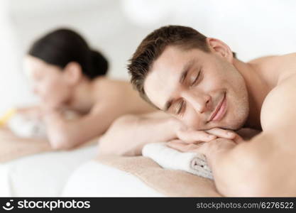 health and beauty, resort and relaxation concept - couple in spa salon lying on the massage desks