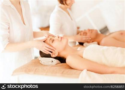 health and beauty, resort and relaxation concept - couple in spa salon getting facial massage