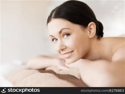 health and beauty, resort and relaxation concept - picture of woman in spa salon lying on the massage desk