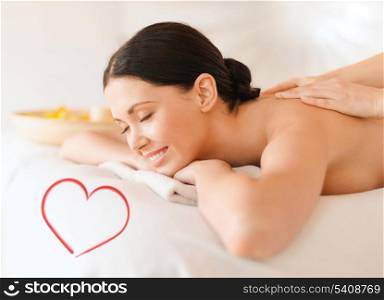 health and beauty, resort and relaxation concept - smiling woman in spa salon getting massage