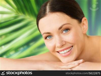 health and beauty, resort and relaxation concept - woman in spa salon lying on the massage desk