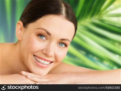 health and beauty, resort and relaxation concept - woman in spa salon lying on the massage desk