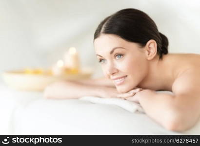 health and beauty, resort and relaxation concept - woman in spa salon lying on the massage desk