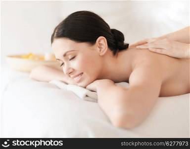 health and beauty, resort and relaxation concept - woman in spa salon getting massage