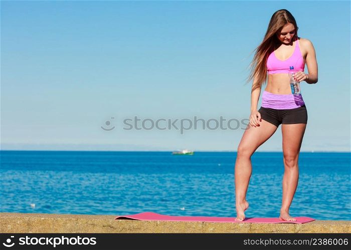 Health and body care idea. Sporty fit attractive woman with bottle of water after exercising workout outdoor.. Woman with water after workout