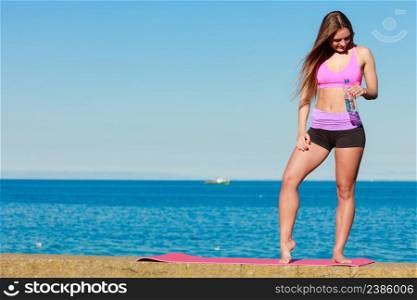 Health and body care idea. Sporty fit attractive woman with bottle of water after exercising workout outdoor.. Woman with water after workout