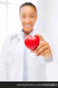 health and charity concept - close up of woman hand holding heart