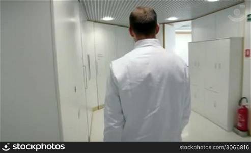 Health and dental care, man working as dentist, meeting with assistant and talking with young female patient in professional laboratory. Steadicam shot