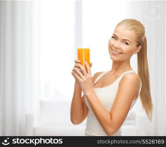 health and diet concept - young woman holding glass of orange juice