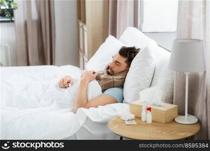 health and people concept - sick man sleeping in bed at home. sick man sleeping in bed at home