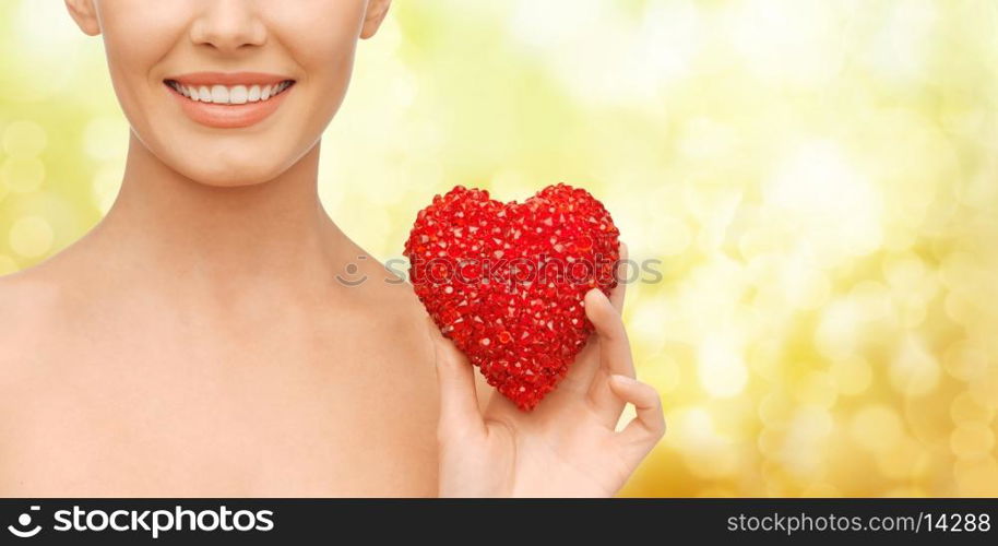 health, beauty and charity concept - beautiful woman with red heart