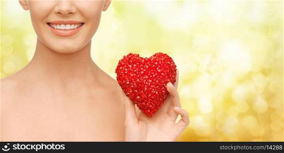 health, beauty and charity concept - beautiful woman with red heart