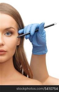 health, beauty and plastic surgery concept - woman face and beautician hands with pencil
