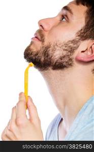 Health beauty and skin care concept. Closeup male face profile. Young man guy styling beard holding disposable yellow razor blade white background.