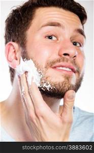 Health beauty and skin care concept. Closeup young bearded man with foam on face preparing to shave, guy shaving