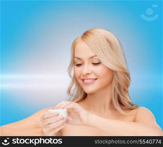 health, beauty and spa concept - beautiful woman applying cream