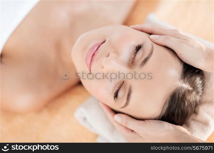 health, beauty, resort and relaxation concept - beautiful woman in spa salon getting face treatment