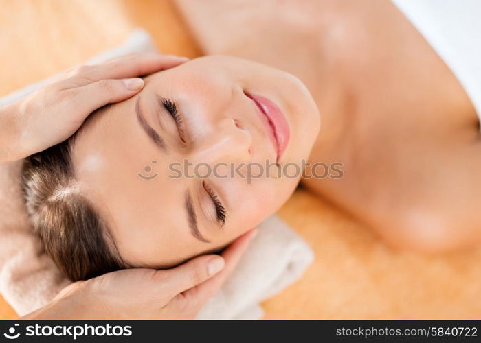 health, beauty, resort and relaxation concept - beautiful woman in spa salon getting face treatment