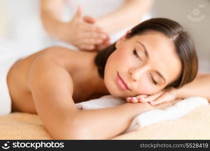 health, beauty, resort and relaxation concept - beautiful woman with closed eyes in spa salon getting massage