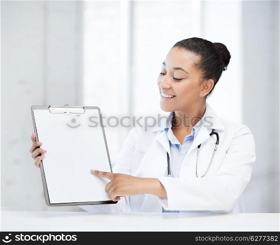 health care and medical concept - female doctor with stethoscope and blank prescription
