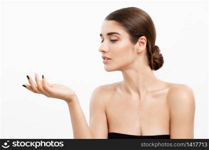 Health care and spa concept - attractive young and healthy woman blowing a kiss from her hand white background. Health care and spa concept - attractive young and healthy woman blowing a kiss from her hand white background.
