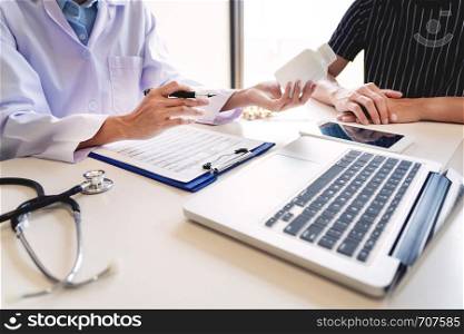 health care concept, doctor give a medicine bottle of drugs pills and explain the direction to use to patient in the hospital.