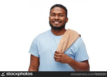 health care, dental hygiene and people concept - smiling african american young man with bath towel on his shoulder over white background. smiling african american young man with bath towel