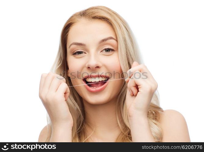 health care, dental hygiene, people and beauty concept - happy young woman or teenage girl with floss cleaning teeth