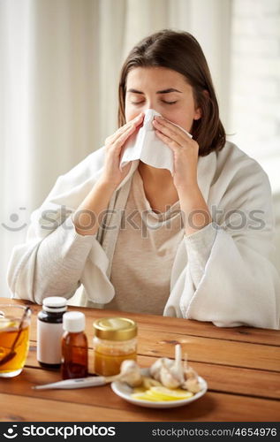 health care, flu, hygiene, age and people concept - sick woman with medicine blowing nose to paper wipe at home