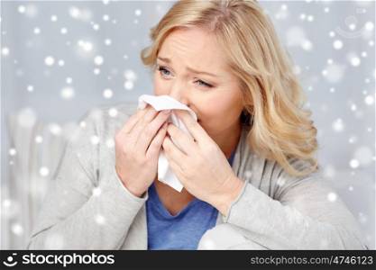 health care, flu, hygiene and people concept - ill woman blowing nose to paper napkin over snow