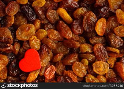 Health care healthy food organic nutrition. Red heart on raisin background texture