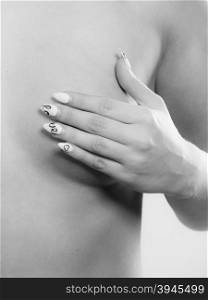 Health care medical concept. Close up young woman examining her breasts for lumps or signs of breast cancer. Black &amp;amp; white image