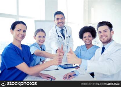 health care, medical education, people and medicine concept - group of happy doctors or interns with mentor meeting and showing thumbs up gesture at hospital