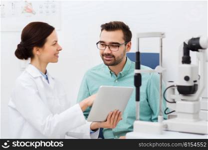 health care, medicine, people, eyesight and technology concept - female optician with tablet pc computer and man in glasses at eye clinic or optics store