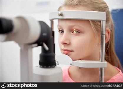 health care, medicine, people, eyesight and technology concept - girl checking vision with tonometer at eye clinic