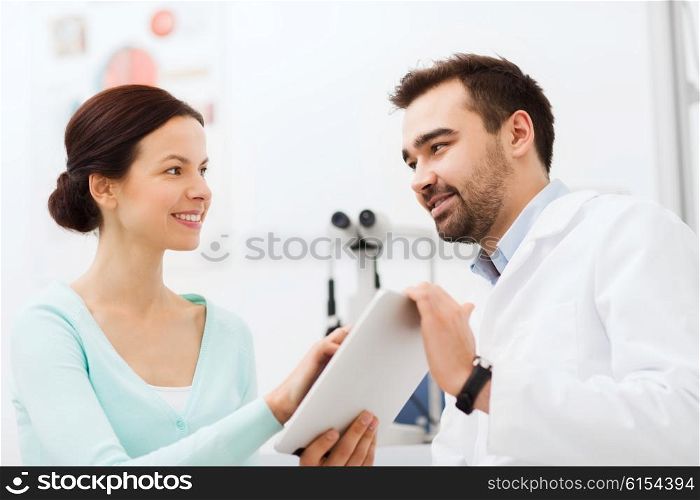 health care, medicine, people, eyesight and technology concept - optician with tablet pc computer and patient at eye clinic or optics store