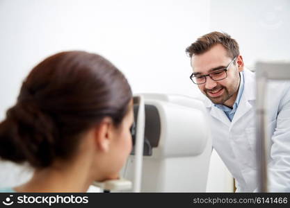 health care, medicine, people, eyesight and technology concept - optometrist with non contact tonometer checking patient intraocular pressure at eye clinic or optics store