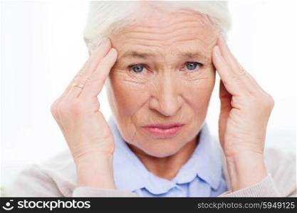 health care, pain, stress, age and people concept - face of senior woman suffering from headache