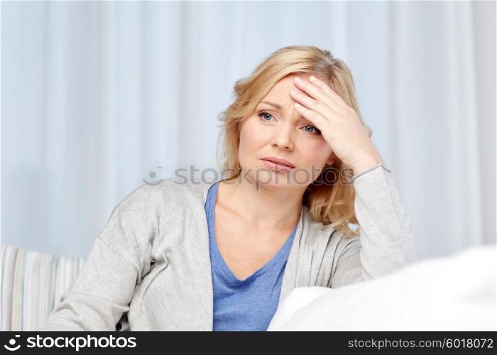 health care, pain, stress and people concept - middle aged woman suffering from headache at home