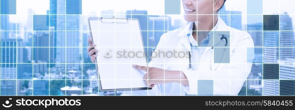 health care, people and medical concept - happy african female doctor pointing finger to blank paper on clipboard over city and blue grid background