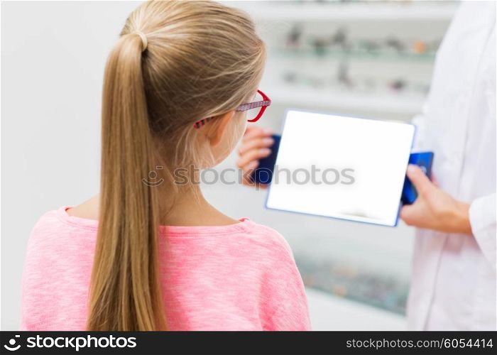 health care, people, eyesight and vision concept - close up of optician with mirror helping little girl to choose glasses at optics store