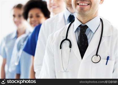 health care, profession, people and medicine concept - close up of happy doctors with stethoscope at hospital