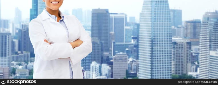 health care, science, people and medical concept - happy african american female doctor in white coat over city background