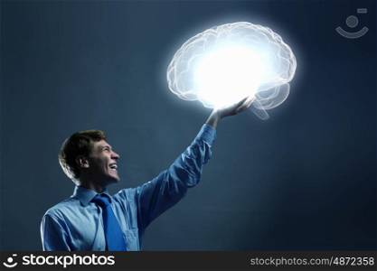 Health care. Young man holding human brain in hand