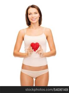 health, charity and beauty concept - beautiful woman in cotton underwear showing red heart