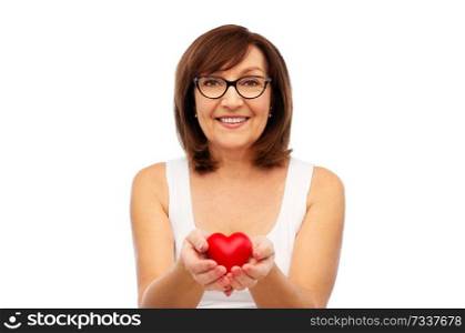 health, charity and valentine&rsquo;s day concept - portrait of smiling senior woman holding red heart over white background. portrait of smiling senior woman holding red heart