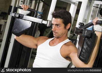 health club: guy in a gym doing weight lifting